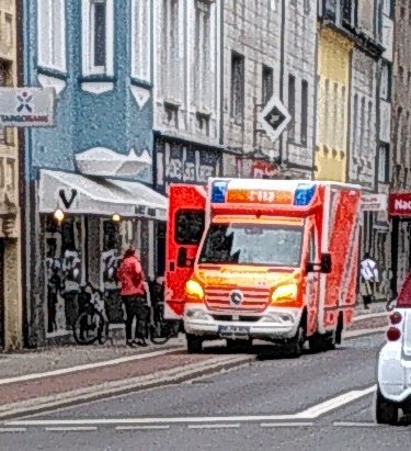 Krankenwagen blockiert Radweg und engt Gehweg ein.