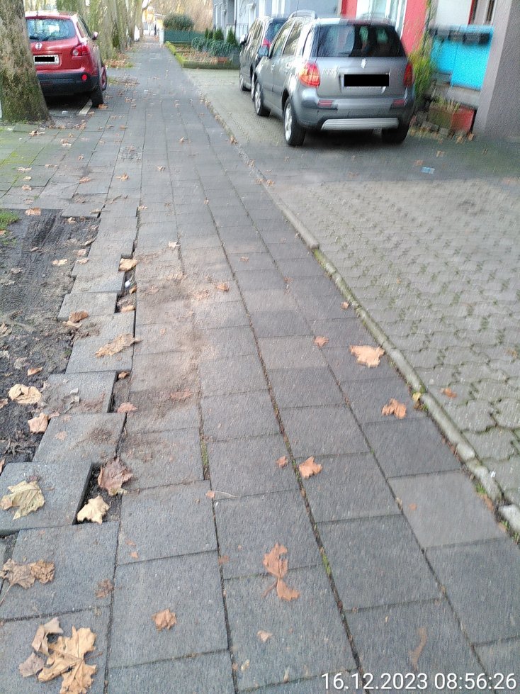 Durch Autoverkehr beschädigter Gehweg in Duisburg Rheinhausen. Etliche Platten sind sichtbar verschoben.