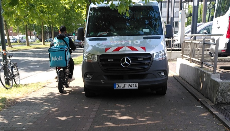 Symbolbild mit KFZ auf Rad und Gehweg Falschparkend