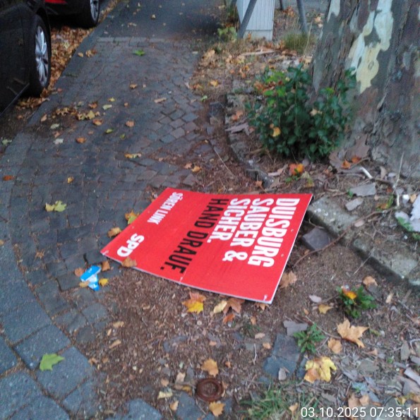 Ein Wahlplakat der SPD liegt auf einem Radweg. Auf dem Plakat steht "Duisburg Sauber und Sicher"