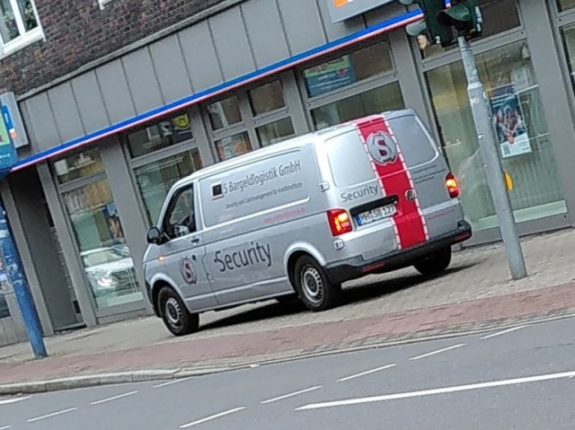 Transporter der S Bargeldlogistik GmbH auf Mitten einem Gehweg stehend mit wenig Platz für Fußverkehr.