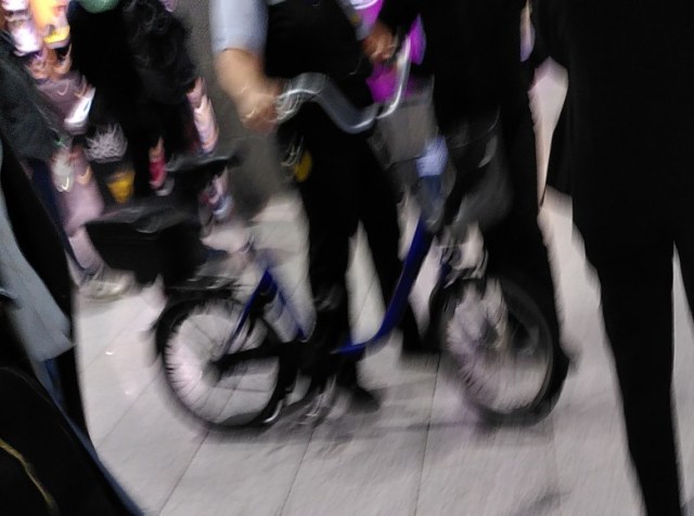 Mitarbeiter des Frankfurter Flughafens mit einem Fahrrad im Gebäude.