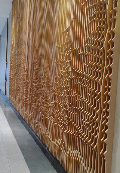 Kunstwerk aus Holz an der Wand, was Schallwellen visualisiert