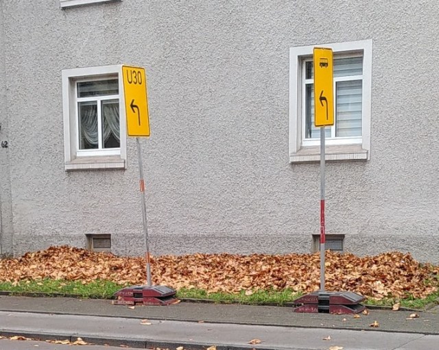 Schilder engen einen Gehweg in Rheinhausen erheblich ein