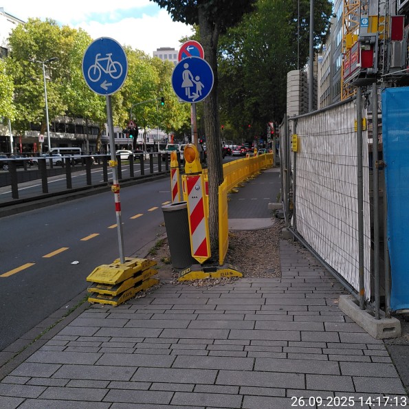 Baustelle blockiert Gehweg an der Immermannstraße, Radverkehr soll auf der Fahrbahn weiter und der Gehweg endet quasi an der Baumscheibe.