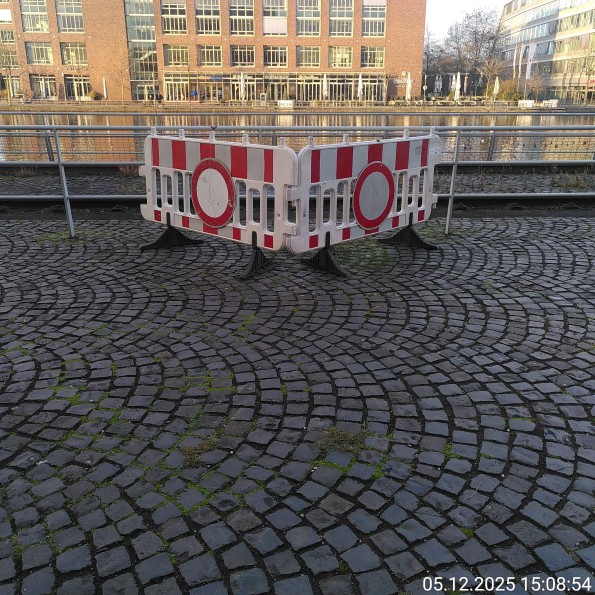 Zwei Absperrbaken mit VZ 250 (Fahrverbot für Fahrzeuge aller Art) am Rand einer großen Fläche.