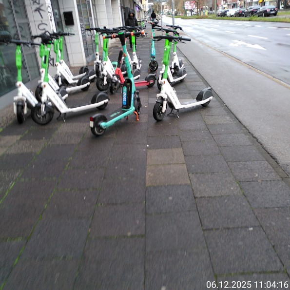 Ihscooter blockieren einen recht breiten Gehweg vollständig durch eine große Anzahl.