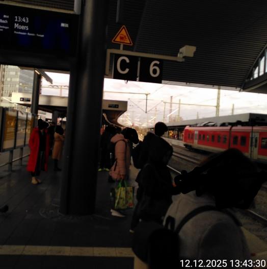 Bahnsteig 6 im HBF Duisburg mit etlichen Wartenden und einem Stück der Anzeigentafel.