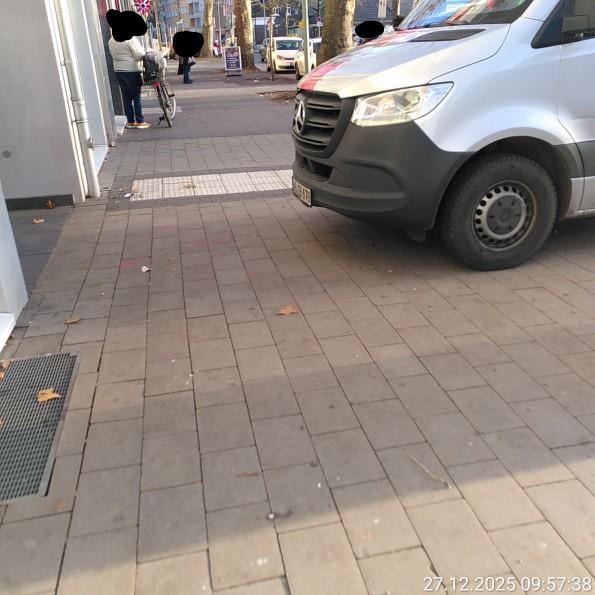 Falschparkender Bargeldtransporter von der Seite mit kleiner Restbreite direkt an einer Haltestelle mit viel Betrieb.