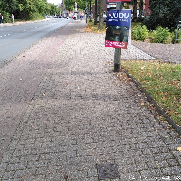 Wahlplakat von Junges Duisburg schränkt einen Gehweg signifikant ein.