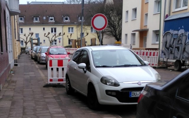 Straße mit zugeparkten Gehweg und Verkehrszeichen 250