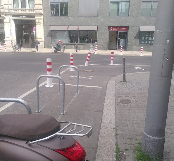 Einmündung mit Pollern und Fahrradparkplätzen