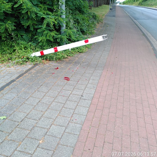 LKW-Sperre von einem LKW so beschädigt, dass ein Pfosten den Gehweg vollständig und den Radweg teilweise blockiert.